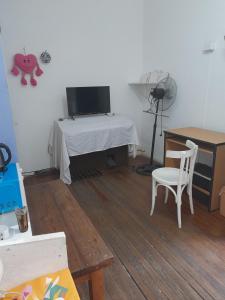 a room with a table and a desk with a television at Casa de Huéspedes Cristina Recoleta Cristina Guesthouse Recoleta in Buenos Aires