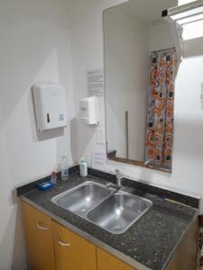 a kitchen with a sink and a mirror at Casa de Huéspedes Cristina Recoleta Cristina Guesthouse Recoleta in Buenos Aires