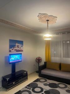 a living room with a couch and a television at Appartement R&eacute;sidence Yassmina in Tangier
