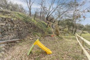 a playground in a field next to a stone wall at Cal Sastre in Biscarri +23 photos