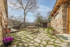 a patio with a wooden picnic table in a yard at Cal Sastre in Biscarri