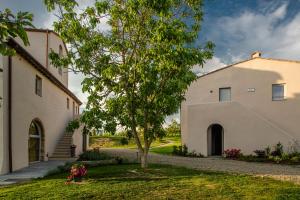 a house with a tree in the front yard at Borgo Elissa Country Relais in Certaldo