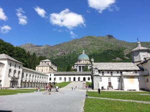 a large building with a mountain in the background at Santuario di Oropa in Biella