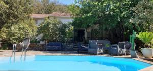 a swimming pool with a bunch of chairs around it at Autour du Hamac chambres et table d'hôtes in Moltifao