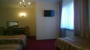 a hotel room with two beds and a television at Hotel E7 in Radom