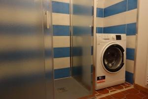 a washing machine in a bathroom with blue and white tiles at La Dimora della Fontana in Mozzio