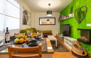 una sala de estar con una mesa con una pared verde en Casa Jaime, en Monachil