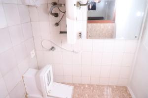 a white bathroom with a toilet and a sink at PAK Heritage Hotel in Lahore