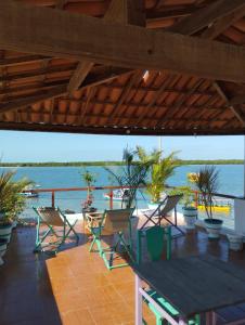 a patio with chairs and a table and the ocean at Pousada Tycoz Flor do mar in Galinhos +52 photos