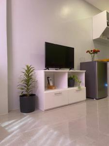 a white entertainment center with a flat screen tv on it at LL-Apartelle in Lo-oc