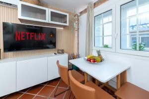 a kitchen with a tv and a white table and chairs at Calas Beach Corralejo in Corralejo