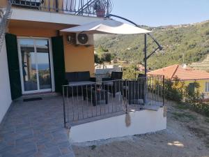 a patio with a table and an umbrella at La casa di Trilly in Sanremo