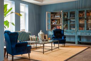 een woonkamer met 2 stoelen en een salontafel bij Grand Hotel Ter Duin in Burgh Haamstede