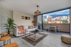 ein Wohnzimmer mit Sofa und Tisch in der Unterkunft Apartamentos Go Living & Suites by HOUSY HOST in Medellín