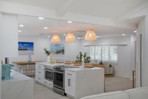 a kitchen with white cabinets and a stove top oven at Sea Glass Villa- Executive Pool Home on Golf Course in Sanibel