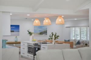 a kitchen and living room with pendant lights at Sea Glass Villa- Executive Pool Home on Golf Course in Sanibel