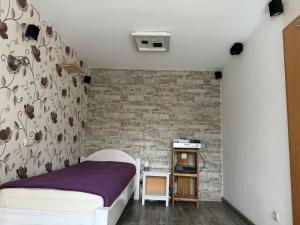 a bedroom with a bed and a brick wall at Messe-Apartment, 4 Schlafzimmer, 80 qm, Garten - 6 km zur Messe, verkehrsgünstig, ruhig, Parkplätze in Nürnberg