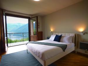 a bedroom with a large bed and a large window at Villa Grel - by MyHomeInComo in Como