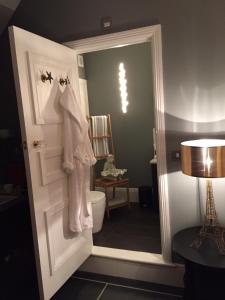 a bathroom with a toilet and a towel hanging on the door at Montpellier House in Milton Keynes