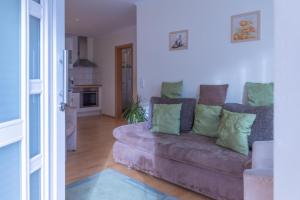 a living room with a couch with green pillows at Ferienwohnung 3 Am Petersberg in Neef