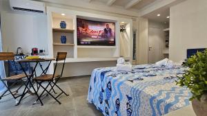 a room with a bed and a table and a tv at Panhouse Rooms & Suite in Palermo