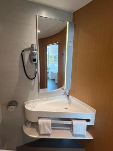 a bathroom with a white sink and a mirror at SoBlue Hôtel in Antibes