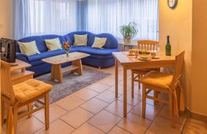 a living room with a blue couch and a table at Ferienwohnung 4 Am Petersberg in Neef