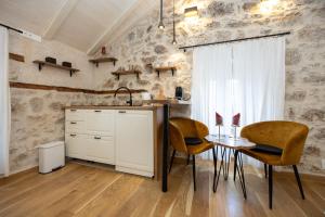 a kitchen with a table and two chairs and a sink at Kruna apartments est 2024 in Split