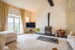 a living room with a fireplace and a stove at Garden Cottage in Kendal