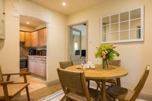 a kitchen and dining room with a wooden table and chairs at Garden Cottage in Kendal