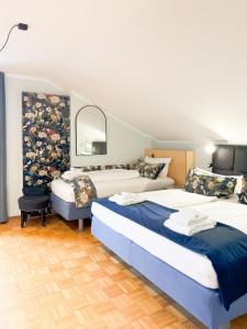 a bedroom with two beds and a mirror at Villa Fantasia Budget Boutique Hotel in Füssen