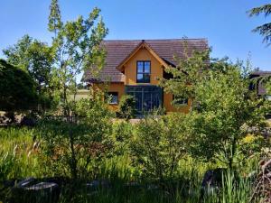 a house with a garden in front of it at Das gelbe Landhaus in Tellig