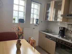 a kitchen with a table with a vase of flowers on it at Ferienwohnung 2 Am Petersberg in Neef