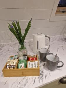 a wooden tray with medicines and a vase on a counter at Bromach Lodge in Latheron