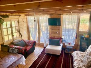 a living room with a couch and chairs and windows at L Ksar, mitten in schönster Natur in Sidi Jedidi