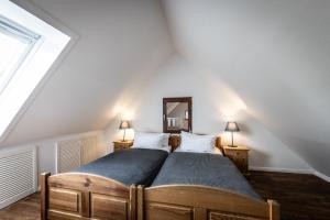a bedroom with a bed with two lamps and a mirror at GH Maisonette Studio Whg 45 in Bastorf