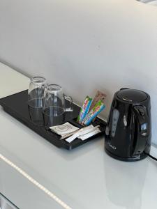 a tray with a tea kettle and glasses on a counter at SoBlue Hôtel in Antibes