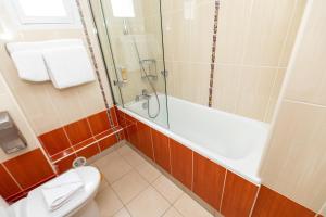 a bathroom with a tub and a toilet and a shower at HOTEL DE PARIS MONTPARNASSE in Paris