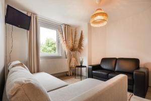 a living room with a couch and a television at Studio in villa Leeuwerik in De Panne