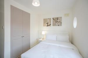 a white bedroom with a bed and a white closet at Grand Canal District Apartments in Dublin