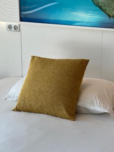 a bed with a brown pillow on top of it at SoBlue Hôtel in Antibes