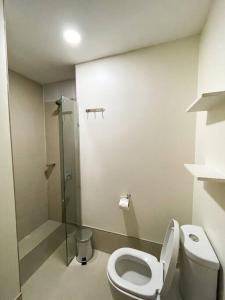 a bathroom with a toilet and a glass shower at Cozy Studio Unit in Abreeza Place Tower 1 with parking in Davao City