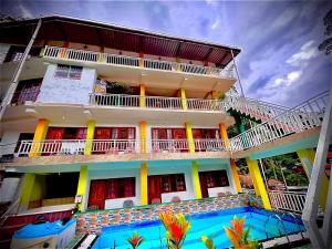 a building with a swimming pool in front of it at Adams peak Grand in Nallathanniya