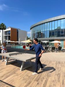 a man is holding a ball on a picnic table at SoBlue Hôtel in Antibes