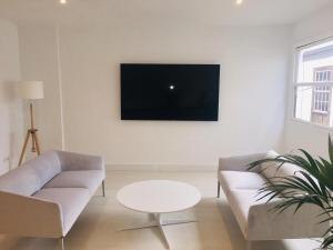 Televízia a/alebo spoločenská miestnosť v ubytovaní Deluxe La Palma