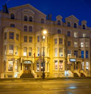 ein großes Gebäude mit Straßenbeleuchtung davor in der Unterkunft Regency Hotel in Douglas