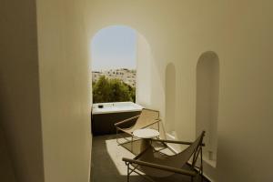 two chairs and a table in a room with a window at Opal Paros in Naousa