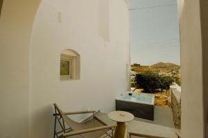 a room with a table and a chair and a window at Opal Paros in Naousa