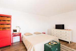 een slaapkamer met een wit bed en een rode dressoir bij Cantinho do Barreiro - Calheta in Calheta