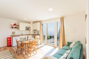 een woonkamer met een groene bank en een tafel bij Cantinho do Barreiro - Calheta in Calheta +11 foto's